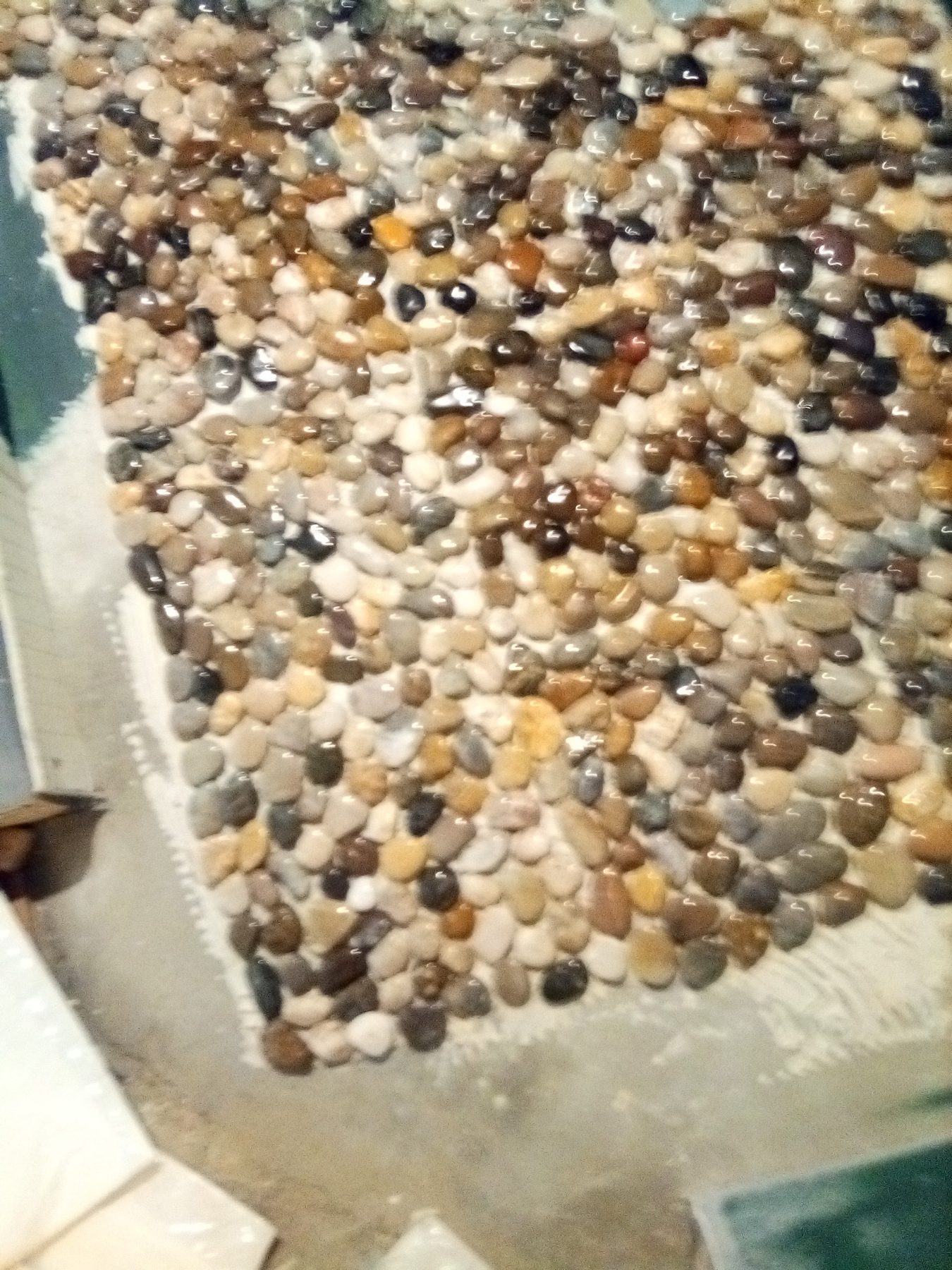 River-rock pebble tile set across the bathroom floor.