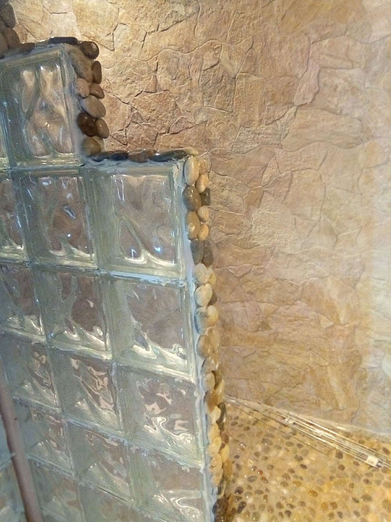 A glass block wall going up beside the stone panel.