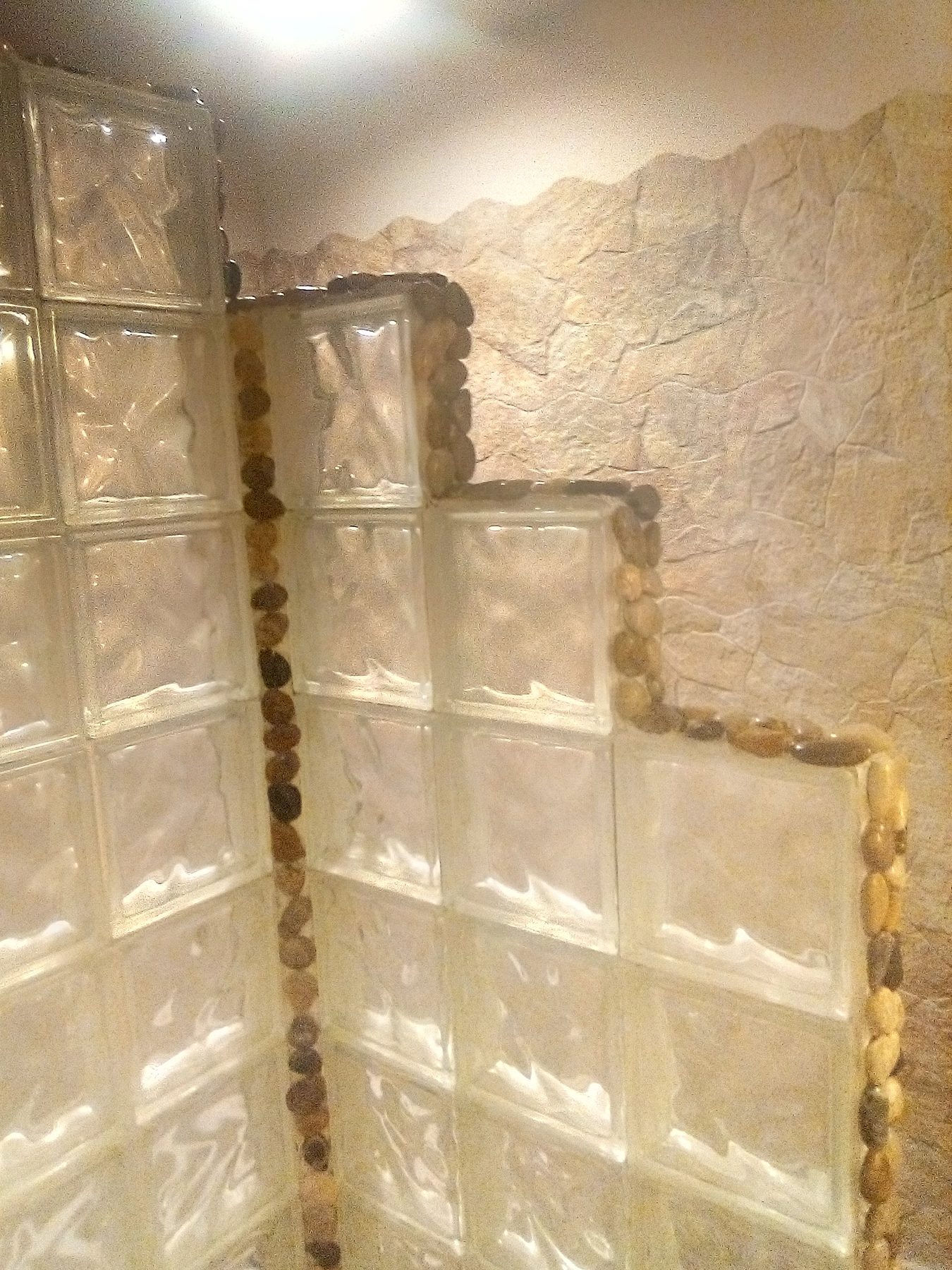 The finished glass block wall with its pebble-set edge.