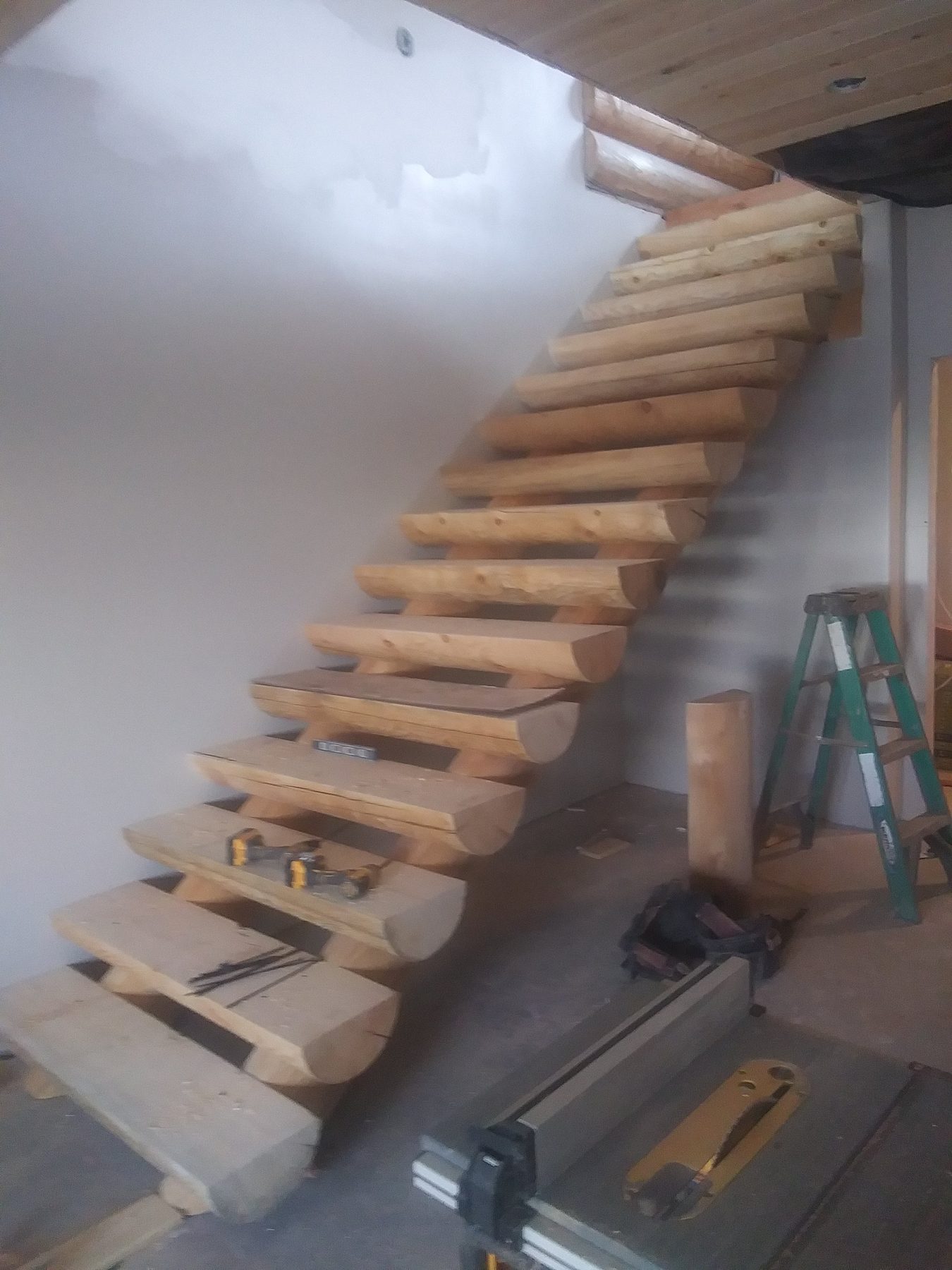 An interior stair of solid timber treads under construction.