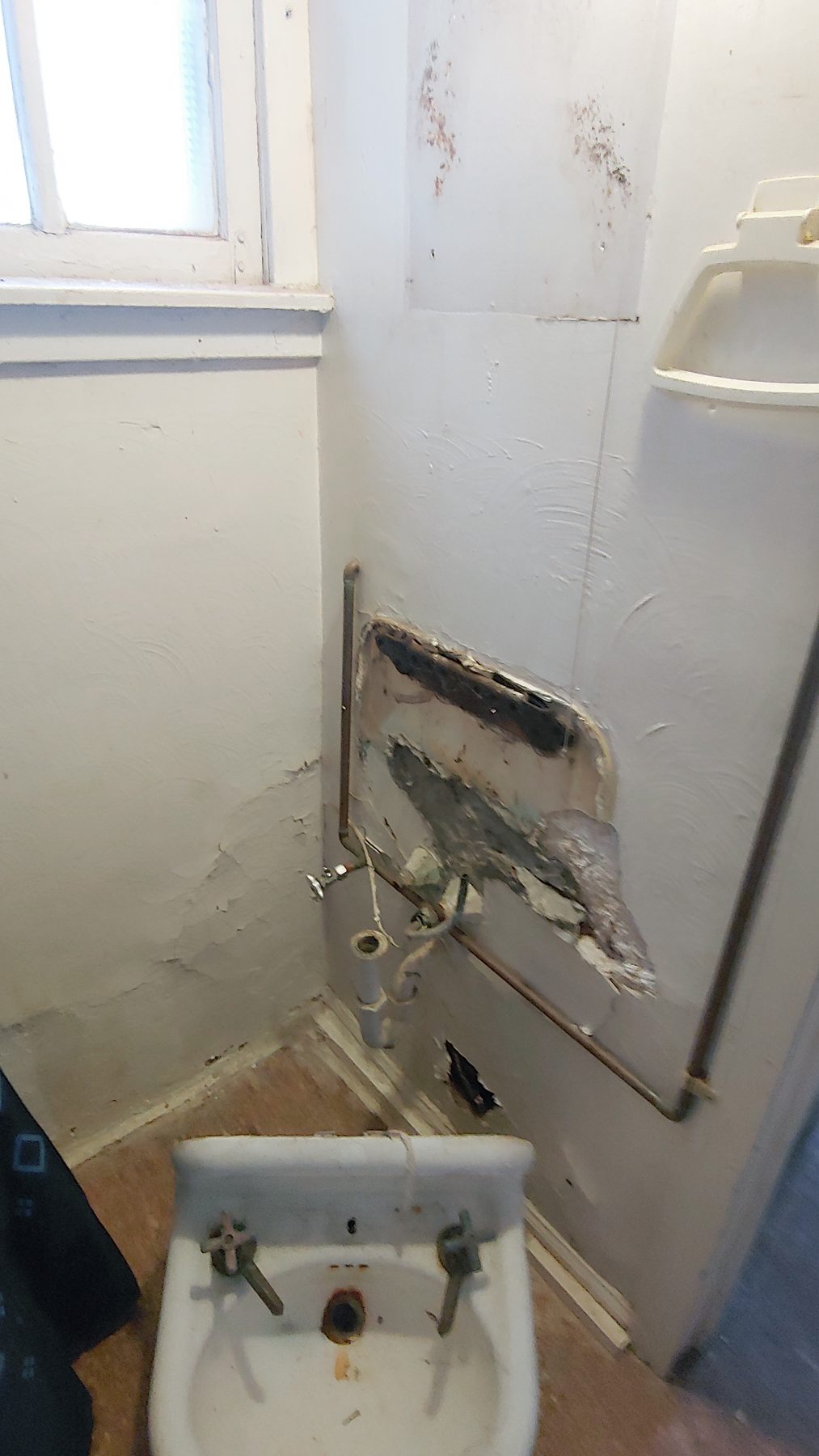 Before: the original bathroom with wall-hung sink and dated fixtures.