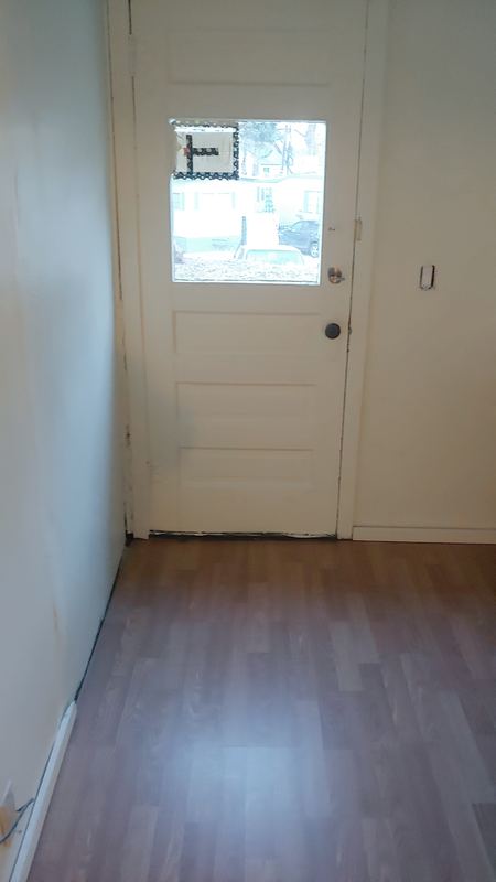 After: new plank flooring running through to the entry door.
