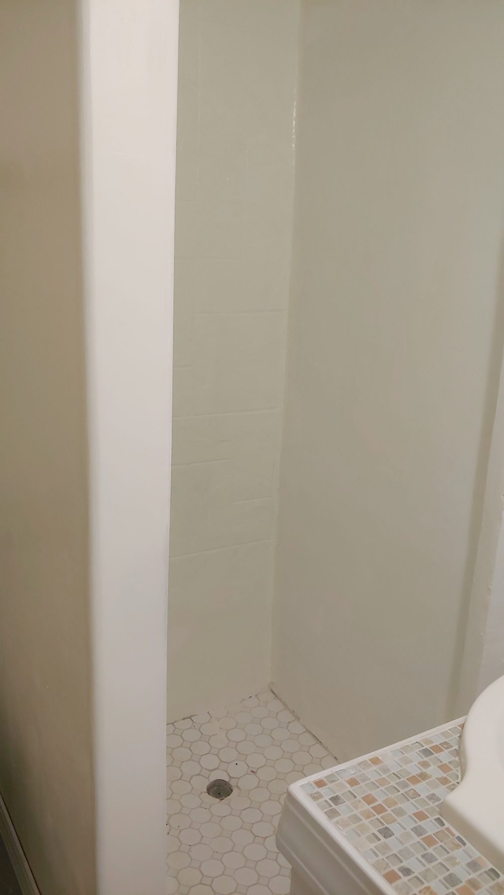 After: tiled shower with a mosaic-topped bench.