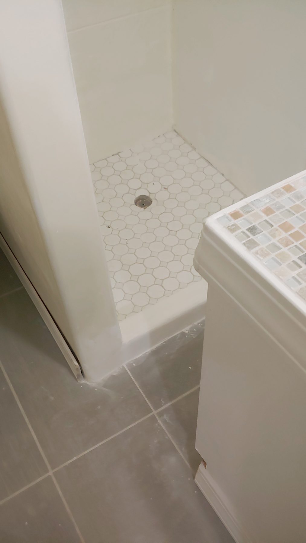 After: the completed bathroom, tile floor through to the shower.