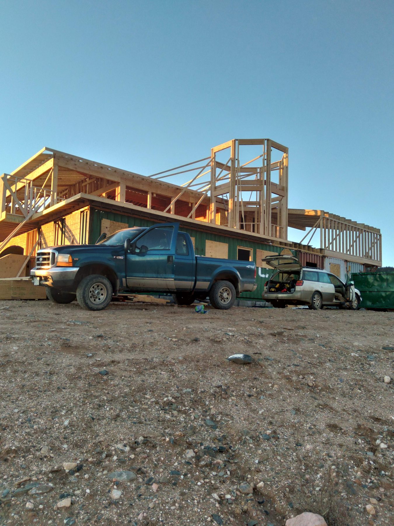 The framed structure stepping down the slope, seen from the drive.