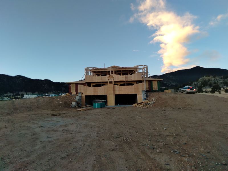 The house from below, garage bays open at the lower level.