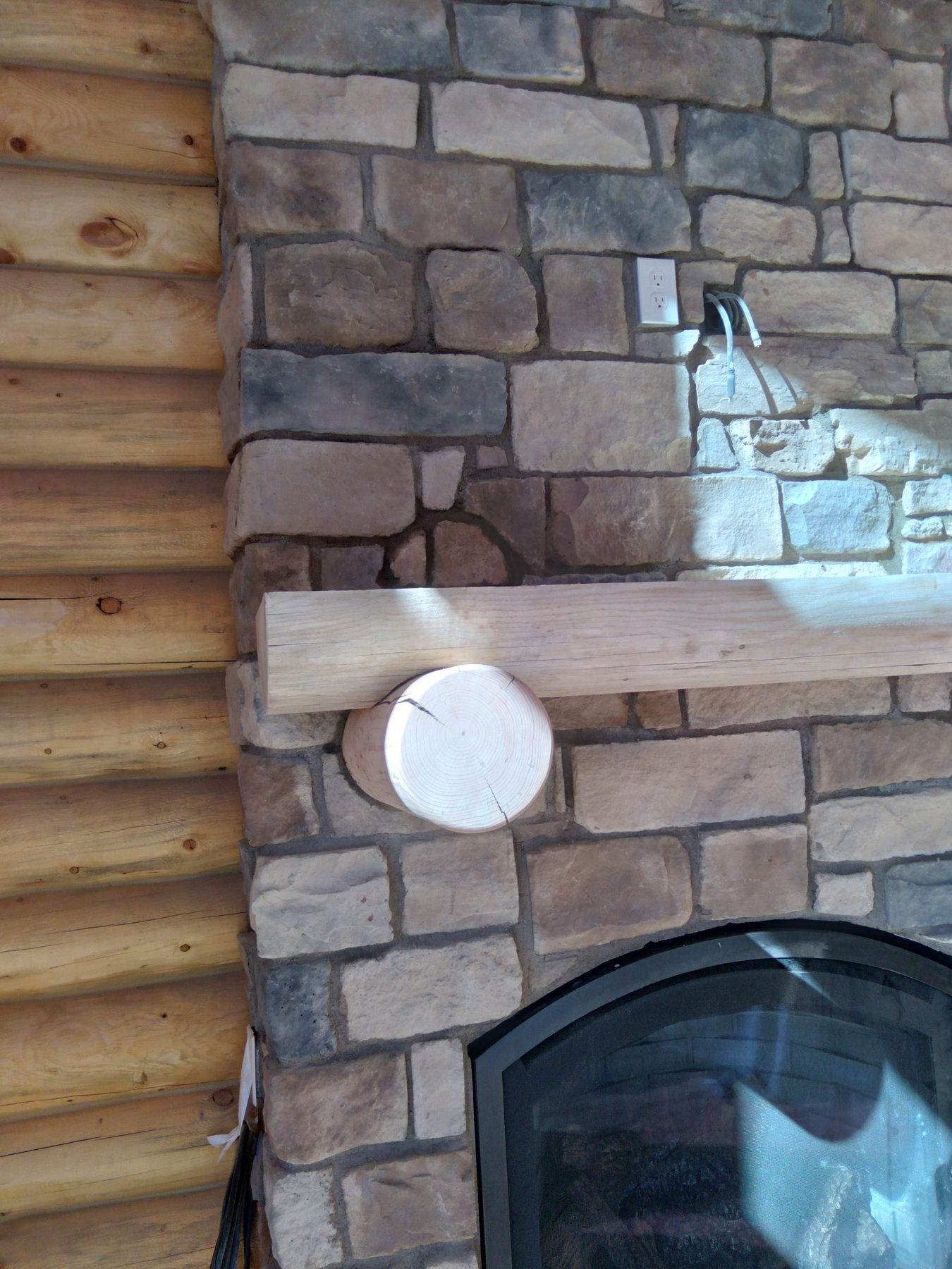 The log mantel set into the stone face.